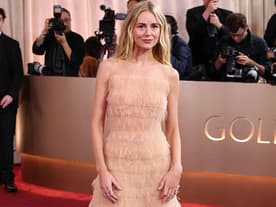 Justine Lupe in einem bodenlangen, nudefarbenen Kleid mit Fransen.