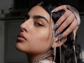 Frau mit silbernen Fingernägeln und Ketten