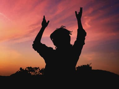 Schatten einer Frau, die die Hände in den Himmel hält