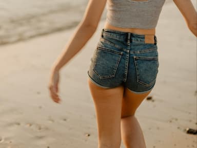 Mädchen mit Jeansshorts am Strand 