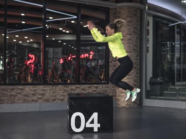 frau springt über block fitness leggings