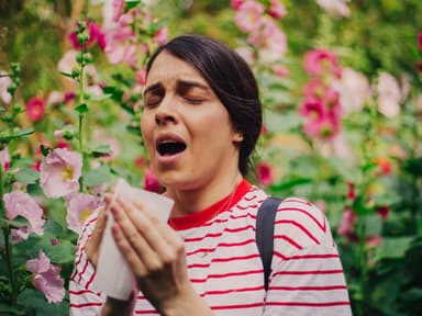 Frau die in der Natur niest