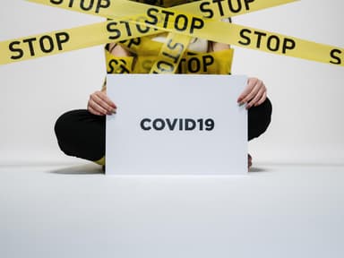 Mensch mit Corona Schild