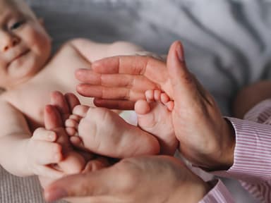 Frau haelt Babyfüße