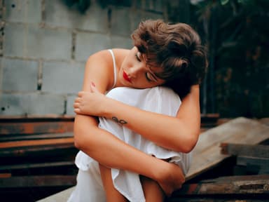 Horoskop: Traurige Frau umarmt sich selbst