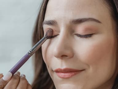 Junge Frau trägt Lidschatten auf Junge Frau trägt Lidschatten auf