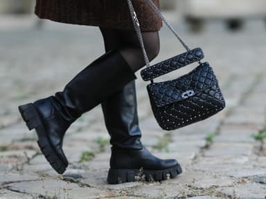 Frau trägt Stiefel mit Handtasche