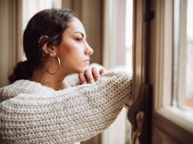 Unglückliche Frau schaut aus dem Fenster