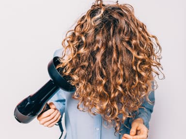 Frau föhnt sich kopfüber Haare