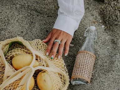 Ring am Finger und Zitrone am Strand