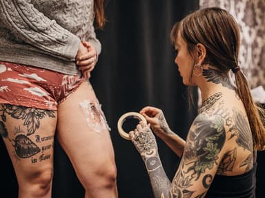 Tätowiererin foliert frisches Tattoo
