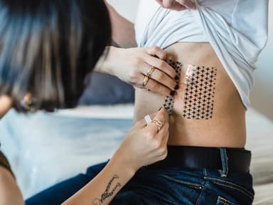 Folie vom Rippen-Tattoo wird abgezogen