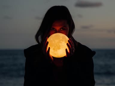 Widder-Vollmond im Oktober Frau mit Vollmond in der Hand