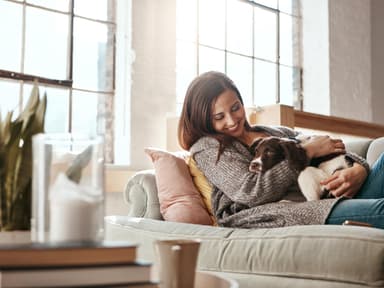 Frau mit Hund auf Sofa