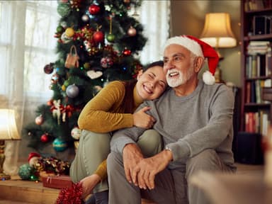 Tochter mit Vater vor Weihnachtsbaum