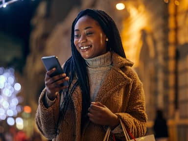 Frau schaut erfreut aufs Handy