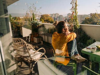Junge Frau auf dem Balkon im Frühling 