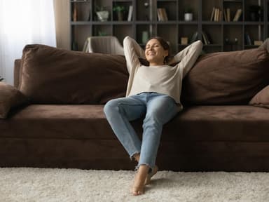 Junge Frau auf Sofa in kleiner Wohnung