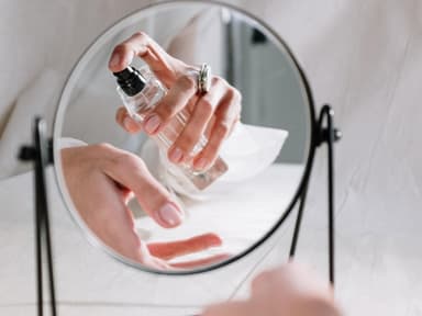 Frau sprüht Parfum auf Frau sprüht Parfum auf