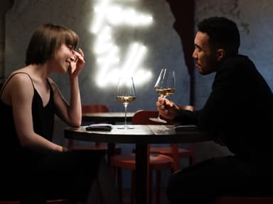 Paar beim ersten Date sitzt an einem Tisch und trinkt Wein.