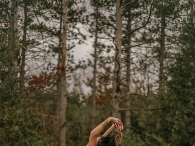 Frau steht in der Natur mit Kleid und Tattoos