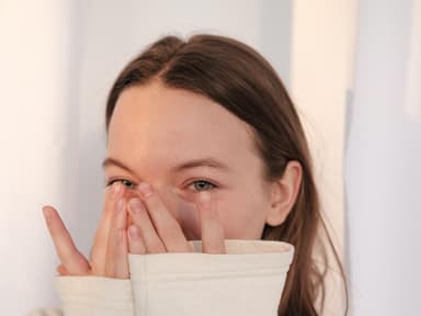 Lachen als Schutzmechanismus: Frau verdeckt ihr lachen