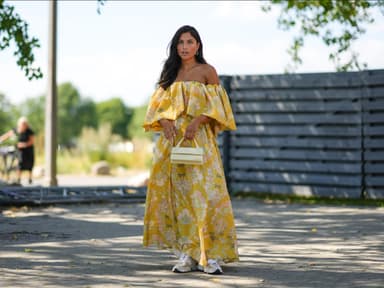 Frau im floralen Maxi-Kleid mit Sneakern