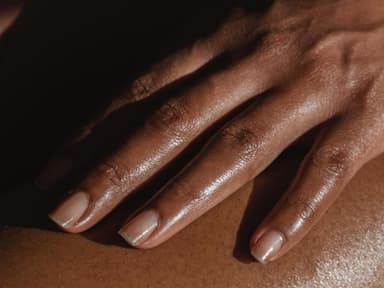Weibliche Hand auf Oberschenkel