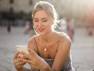 Junge Frau schaut auf Smartphone