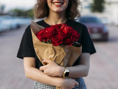 Frau hält einen Strauß mit roten Rosen in der Hand