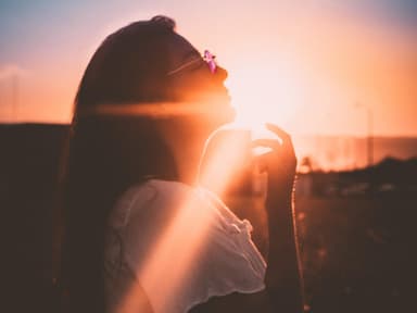 Frau mit langen Haaren und Brille beim Sonnenuntergang
