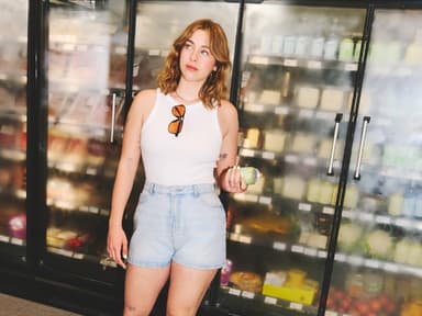 Frau mit Denim-Shorts und weißem Tanktop 