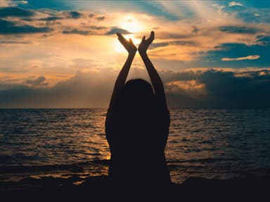 Silhouette einer Frau am Strand mit dem Meer im Hintergrund