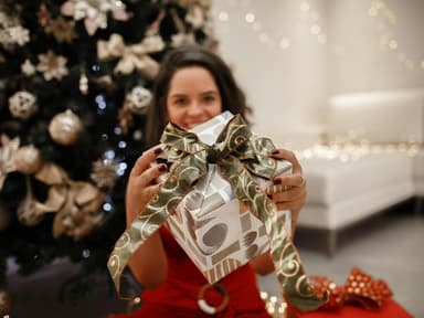 Frau mit Weihnachtsgeschenk in der Hand