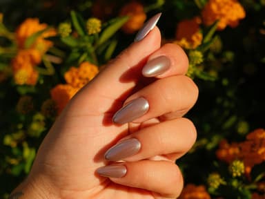 weibliche Hand mit braunem Chrome Nagellack