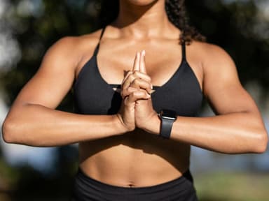 Trainierte Arme sind endlich auch im heutigen Zeitalter angekommen. Der Oberkörper einer Frau mit einem schwarzen Sport-BH, die ihre Hände vor der Brust zusammendrückt.