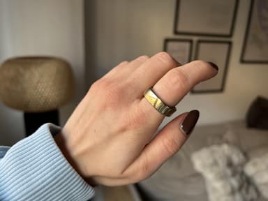 Ein goldener Ring am Zeigefinger einer Hand.