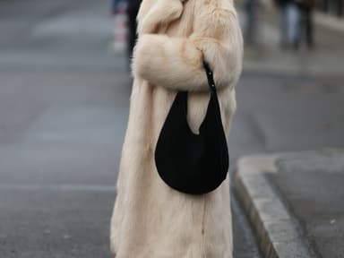 Frau in dickem Fellmantel mit großer Slouchy Bag