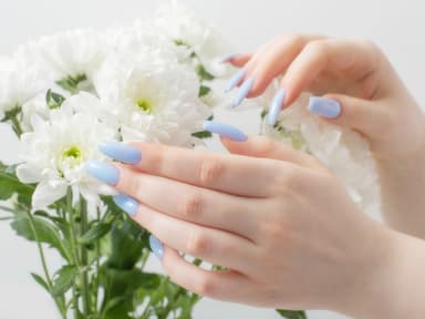 Hände mit hellblauen Nägeln und weiße Blumen Hände mit hellblauen Nägeln und weiße Blumen